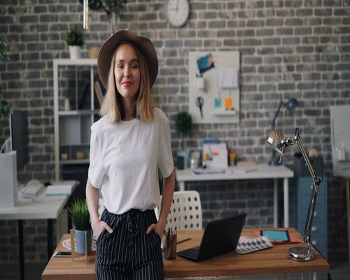 A person standing next to their office desk